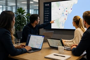 Bindi Maps team collaborating at a table looking at a map dashboard