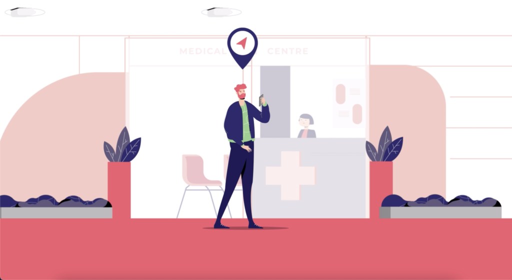 Colourful blue and red and white illustration of a jaunty looking man holding a phone and standing in front of a medical centre reception desk. The ground is a light red, and he is in all blue and looks happy to have found the place using BindiMaps!