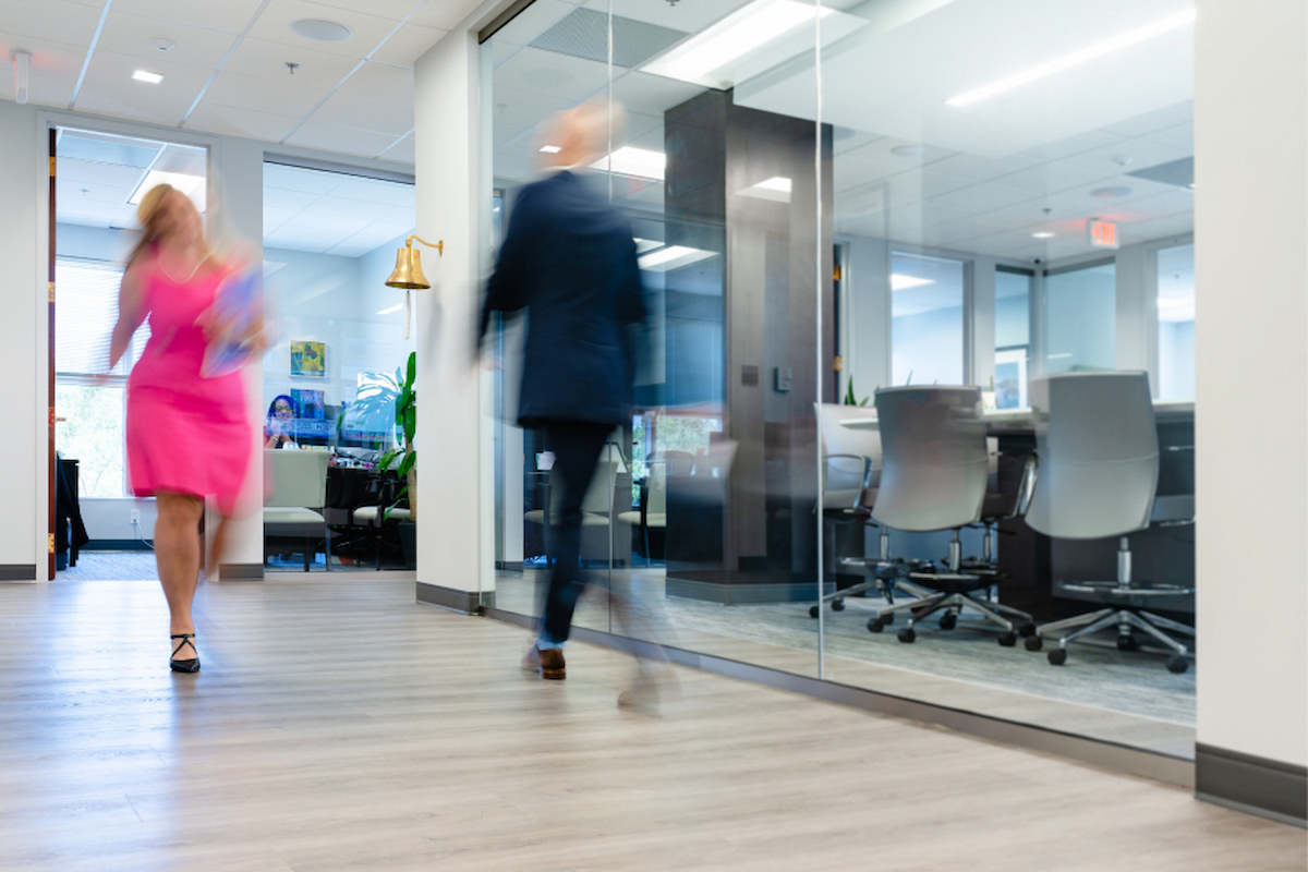 Office building with people walking back up and down the hallway