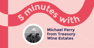 Light Pink background with the title in a wavy red curve, mentioning, '5 minutes with' The curve is dark red and the text is in white bold font. Below the title it highlights, 'Michael Perry from treasury Wine Estates' On left of this text is a headshot of Michael places in a circular shape. The headshot is black and white in colour.